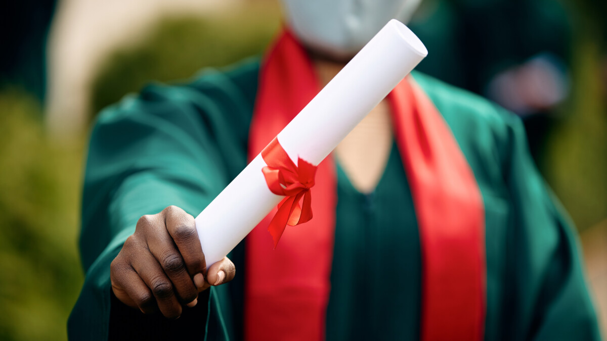 Close-up of African American graduate holding university certificate.